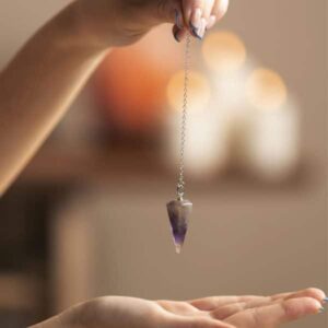 Illustration symbolique d’un soin énergétique de l’âme utilisant un pendule